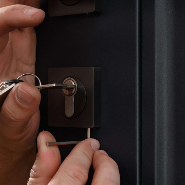 Installation of a door lock, a carpenter installs a door lock in a door, work close-up.